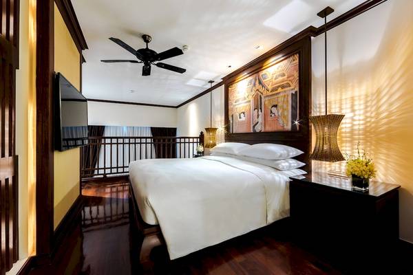 Schlafzimmer im JW Marriott Khao Lak Resort mit Bett, Fernseher und Dekor.