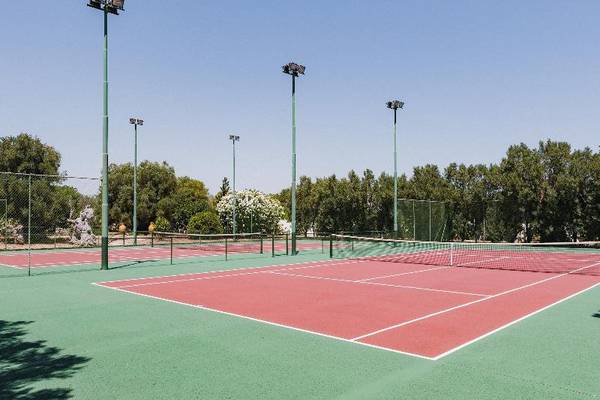 Tennisplatz im Freilichtmuseum mit roten und grünen Spielflächen und Flutlichtern.