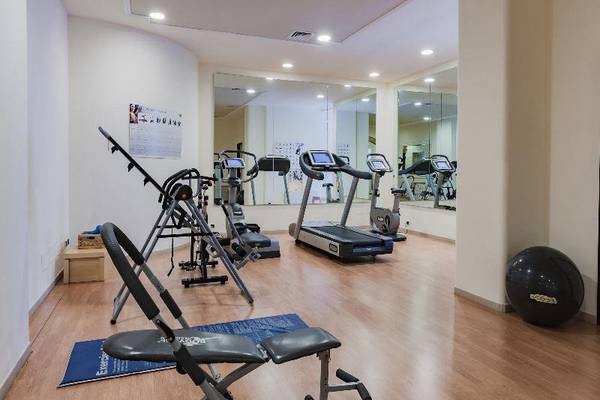 Fitnesscenter im Hotel Il Melograno mit verschiedenen Trainingsgeräten und einem großen Fitnessball.