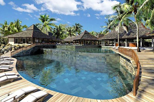 Außenansicht des Infinity-Pools des Zilwa Attitude Hotels mit holzigen Wegen und Sonnenliegen.