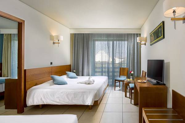 Hotelzimmer im Blue Lagoon Resort mit zwei Betten, Fernseher und Tisch.