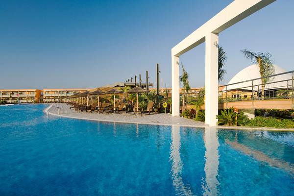 Poolbereich des Blue Lagoon Resorts mit Loungeliegen und umliegenden Gebäuden