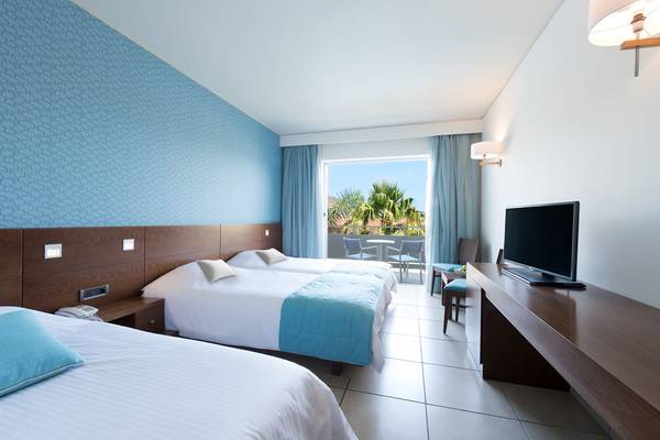 Hotelzimmer im Blue Lagoon Resort mit drei Betten und einem Balkon.