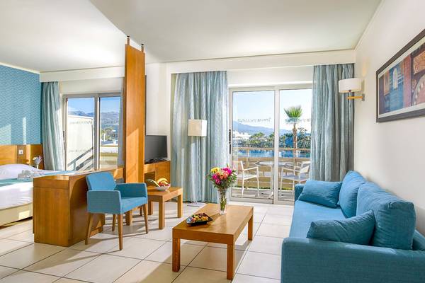 Innenansicht eines Hotelzimmers im Blue Lagoon Resort mit Balkon, Fernseher und Möbeln.
