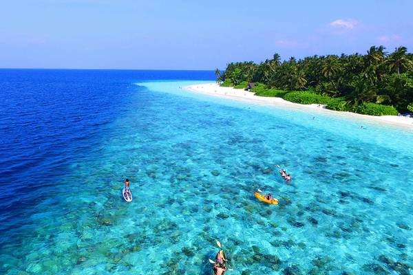 Luftaufnahme des Fihalhohi Island Resorts mit mehreren Personen im klaren Wasser und einer weißen Sandbank.