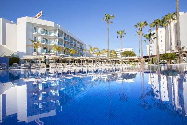 Ein blauer Swimmingpool vor dem Hipotels Cala Millor Park Hotel mit vielen Sonnenliegen und Palmen.