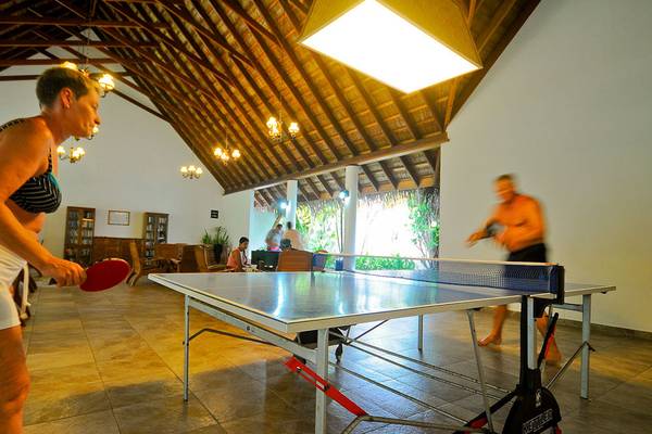 Indoor Ping-Pong Spiel im Fihalhohi Island Resort mit einer Frau und einem Mann.