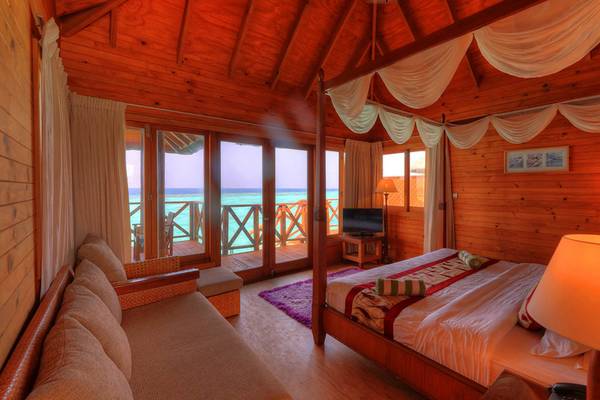 Innenansicht eines Zimmers im Fihalhohi Island Resort Hotel mit Blick auf das Meer.