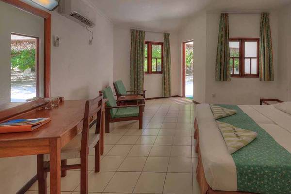 Doppelzimmer im Fihalhohi Island Resort mit zwei Betten, Schreibtisch und Fenstern.