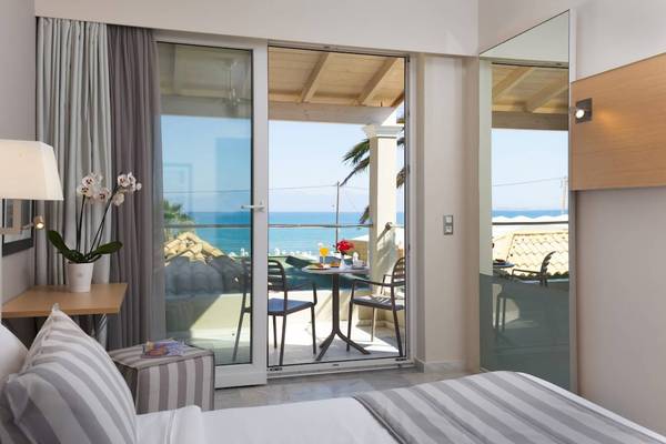 Hotelzimmer mit Meerblick im Acharavi Beach Hotel mit Balkon, Tisch und Stühlen.