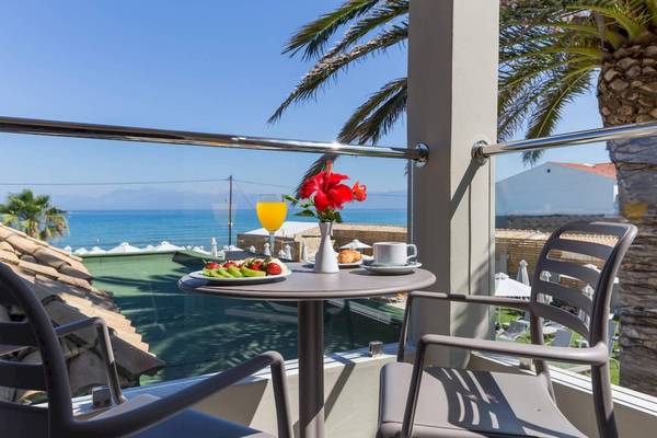 Balkon des Acharavi Beach Hotel mit Blick auf das Meer und Palmen.