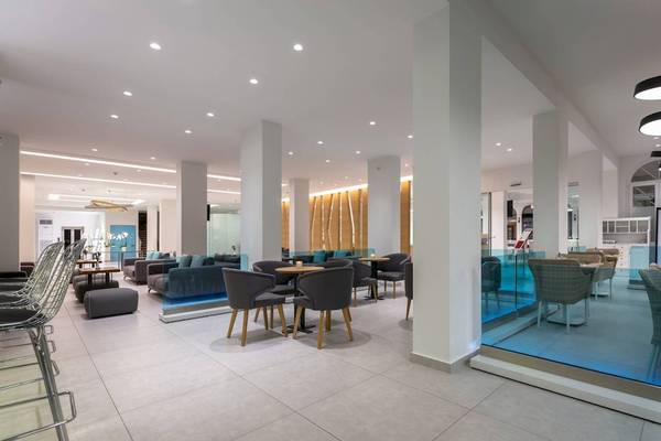 Innenansicht der Lobby des Acharavi Beach Hotel mit modernen Möbeln und hellem Design.