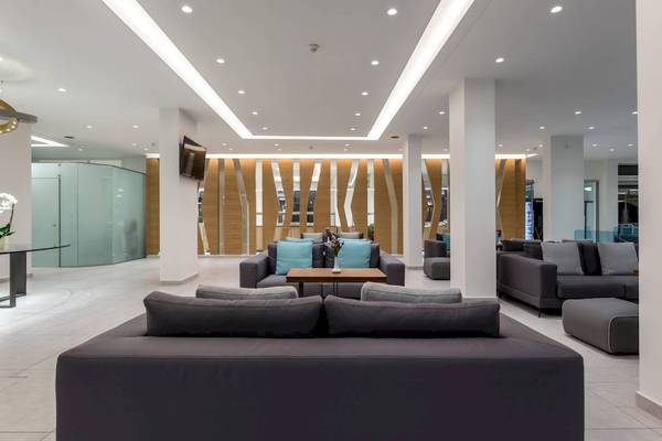 Innenansicht der Lobby des Acharavi Beach Hotel mit modernen Möbeln und Holzelementen.