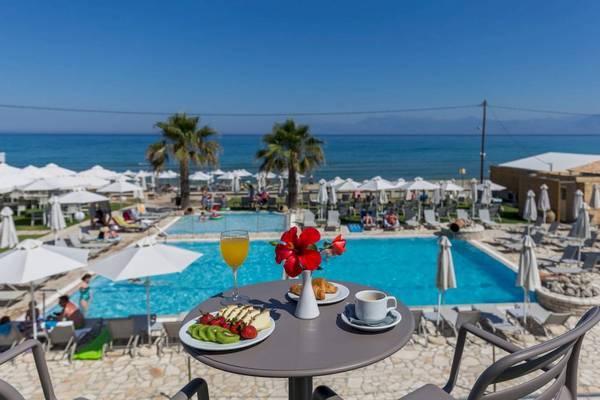 Frühstück am Pool des Acharavi Beach Hotels mit Blick auf das Meer und einen Swimmingpool.
