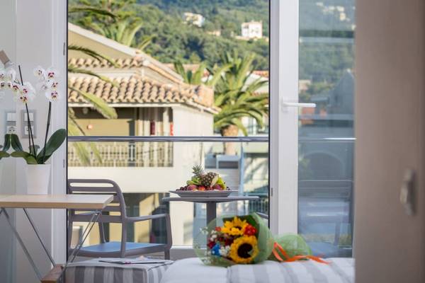 Blick aus dem Hotelzimmer auf eine Terrasse mit Früchten und Blumenstrauß.