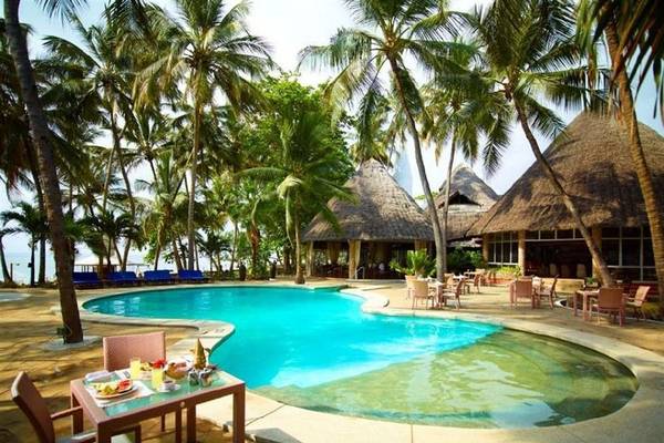Poolbereich im Severin Sea Lodge Hotel mit Palmen und Bungalows.