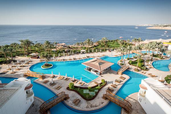 Luftaufnahme des Siva Sharm Resort & Spa mit mehreren Swimmingpools und Sonnenliegen am Meer.