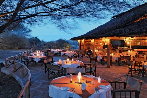 Außenbereich des Severin Sea Lodge Hotels mit abendlicher Beleuchtung, Tischen und Stühlen.