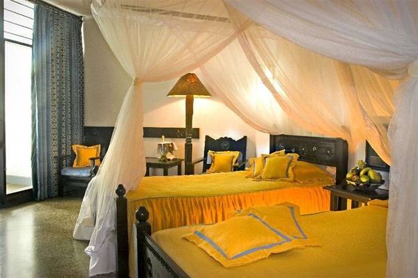 Doppelbett-Zimmer im Severin Sea Lodge mit gelben Bettwäsche und Vorhängen.
