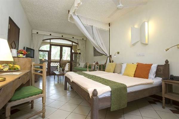 Doppelbettzimmer im Severin Sea Lodge Hotel mit grüner Bettwäsche und vielen Kissen.