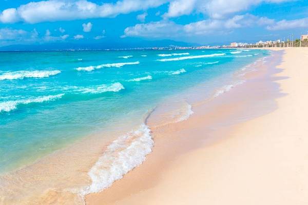 Strand des HM Gran Fiesta Hotels mit blauem Wasser und weißen Wellen