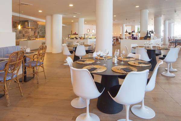 Innenansicht des Restaurants im HM Gran Fiesta Hotel mit modernen Möbeln und Holzboden.