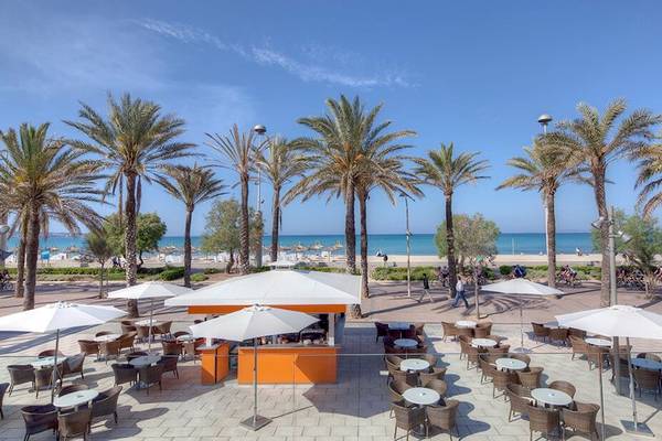 Außenterrasse des HM Gran Fiesta Hotels mit Palmen und Blick auf den Strand