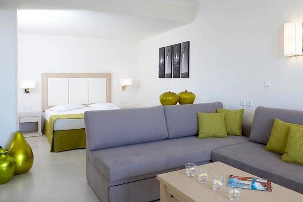 Innenansicht eines Zimmers im Electra Palace Rhodes Hotel mit Doppelbett, Sofa, grünen Vasen und modernen Lampen.