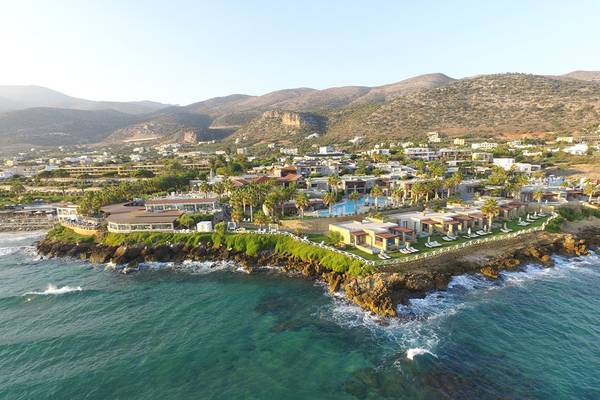 Luftaufnahme des Ikaros Beach Luxury Resort & Spa mit Blick auf die Küste und Berge