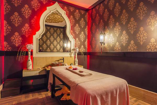 Spa-Behandlungsraum in der Villa Side Residence mit rotem Wanddesign und orientalischen Mustern.