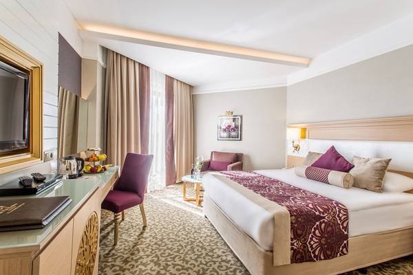 Hotelzimmer der Villa Side Residence mit großem Bett, Dekor und Einrichtungsgegenständen.