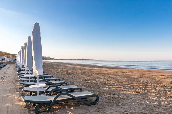 Reihe von Sonnenliegen am Strand der Villa Side Residence