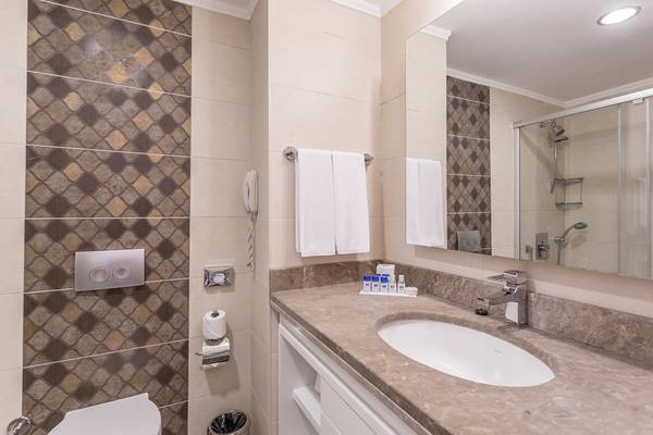 Badezimmer in der Villa Side Residenz mit Waschbecken, Spiegel und Toilette.