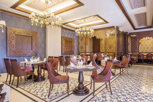 Inneneinrichtung des Restaurants im Villa Side Residence Hotel mit gemusterten Teppichen, Holzmöbeln und Kronleuchtern.