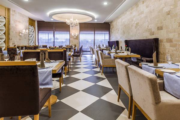Innenansicht des Restaurants der Villa Side Residence mit gemustertem Boden und elegant eingerichteten Tischen.