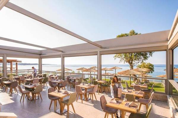 Innenansicht des Restaurants im Cactus Mare Hotel mit Blick auf das Meer und Sonnenschirme.