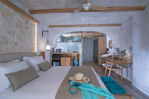 Innenansicht eines Schlafzimmers im Cactus Mare Hotel mit Bett, Schreibtisch, Kleiderschrank und Deckenventilator.
