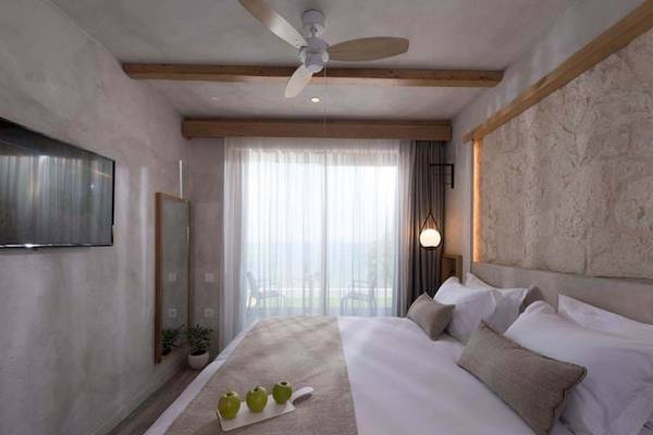 Schlafzimmer im Cactus Mare Hotel mit einem Bett, frischen Äpfeln auf einem Tablett und einer modernen Einrichtung.