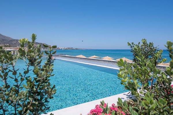 Außenansicht des Pools im Cactus Mare Hotel mit Blick auf das Meer und umliegenden Pflanzen.