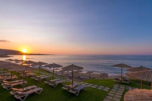 Sonnenuntergang am Strand des Cactus Mare Hotels mit vielen Sonnenliegen und Sonnenschirmen.