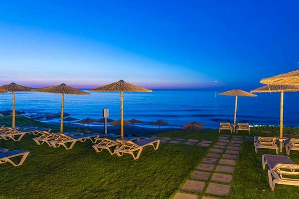 Strandszene mit Lounge-Sonnenliegen bei Sonnenuntergang im Cactus Mare Hotel.