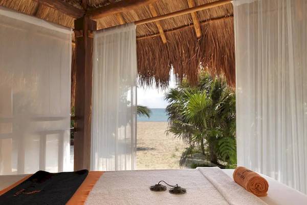 Ein Bett im Hotel Paradisus Playa del Carmen mit Blick auf den Strand und das Meer.
