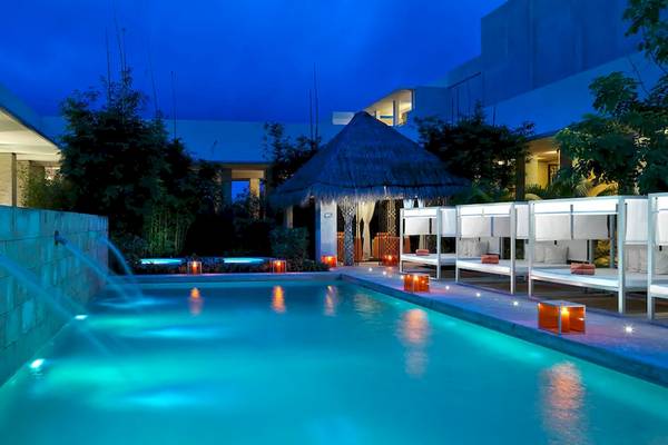 Pool im Freien des Paradisus Playa del Carmen bei Nacht mit blauem Licht.