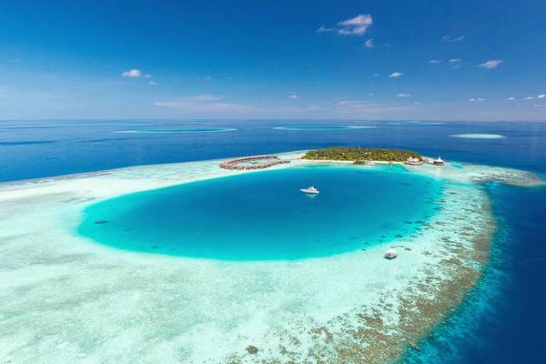 Luftaufnahme des Baros Maldives Resorts auf einer Insel mit Booten im Wasser