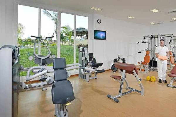 Fitnessraum im Melia Marina Varadero Hotel mit vielen Geräten und einem Mann in weißer Kleidung.