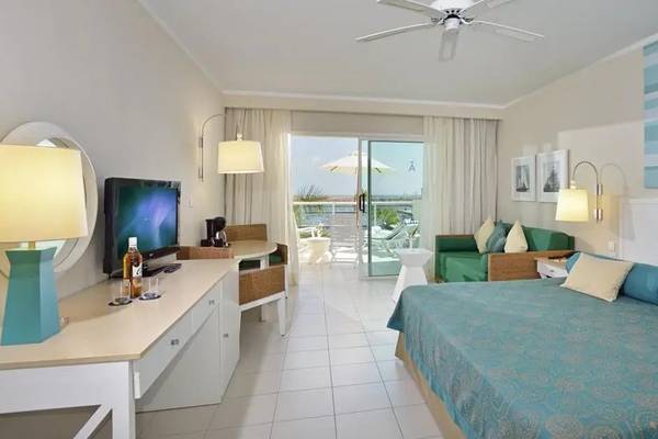 Hotelzimmer im Melia Marina Varadero mit Bett, Fernseher, Schreibtisch und Balkon.