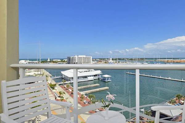 Blick vom Balkon des Melia Marina Varadero auf den Hafen mit weißen Stühlen und einem Tisch.