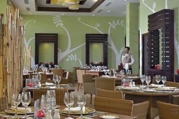 Innenansicht des Restaurants im Melia Marina Varadero Hotel mit gedeckten Tischen, Stühle und ein Kellner in der Mitte.