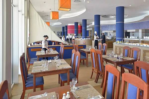Innenansicht des Restaurants im Melia Marina Varadero Hotel mit blauen Säulen und Holztischen.