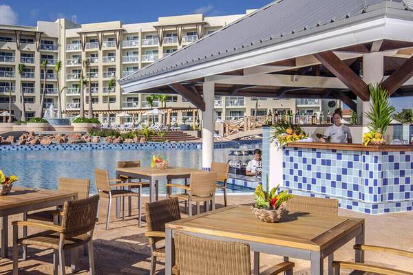 Außenbereich des Melia Marina Varadero Hotels mit Pool und Loungestühlen.